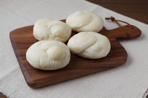 istock baked white bread on wood cutting board isolated on table 1066489672