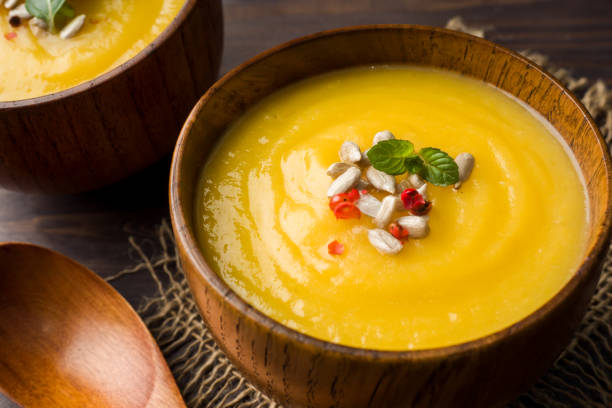 istock Pumpkin soup mashed with spices in wooden bowls on dark boards. 1066489960