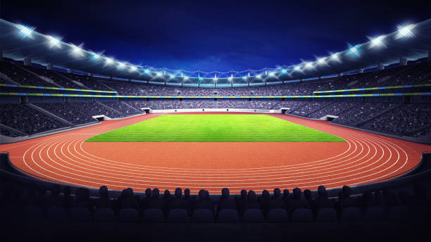 istock athletics stadium with track and grass field at front night view 1066490280