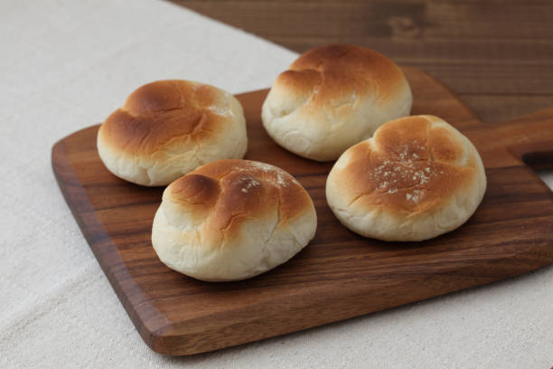 istock baked white bread on wood cutting board isolated on table 1066492228