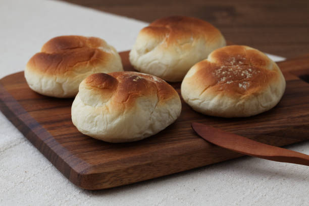 baked white bread on wood cutting board isolated on table