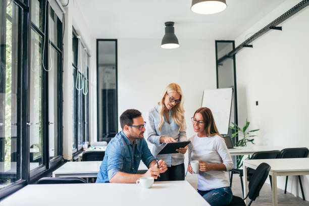 istock Young colleagues watching document and smiling in modern office. Teamwork and brainstorming concept. 1066494278