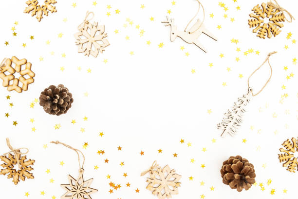 istock Christmas pattern with wooden tree decoration, snowflakes and pine cones on white. Flat lay, top view. Winter festive frame concept. 1066494304