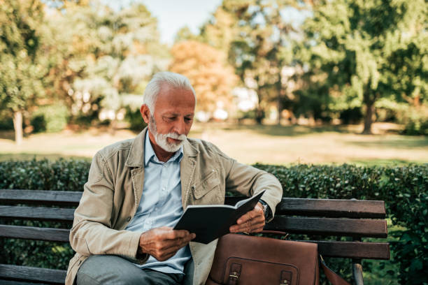 istock Senior enjoy reading book in the park. 1066494368