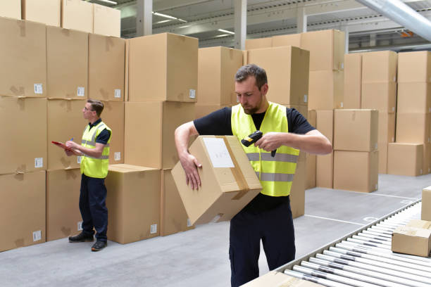 istock Worker in a warehouse in the logistics sector processing packages on the assembly line  - transport and processing of orders in trade 1066494820