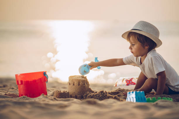 istock Cute boy playing with toys in sand on the beach. 1066495248