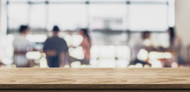 istock Empty wood table with blur people in coffee shop background bokeh light and leaf foreground,Mock up for display or montage of product,Banner for advertise on online media,business presentation. 1066508382