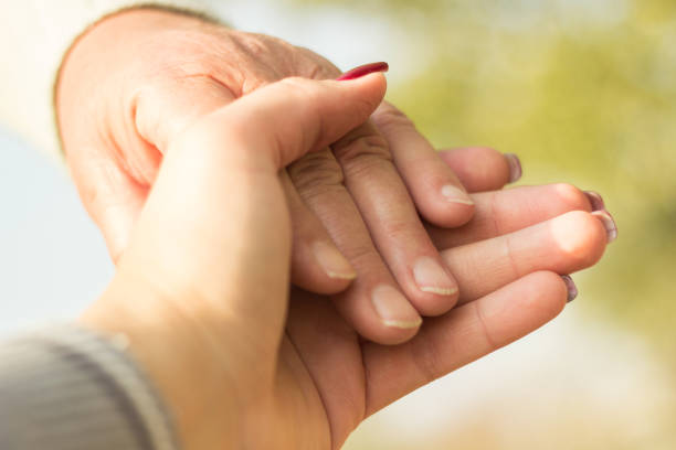 istock Senior and young hands, bokeh background 1066508736