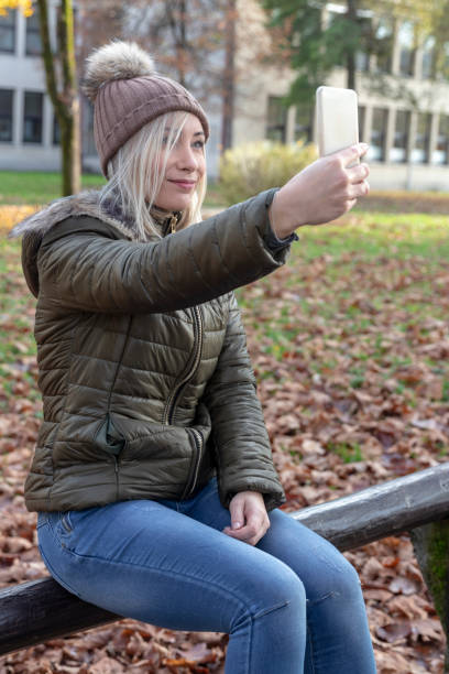 istock Young blond woman making selfies in a park 1066510850