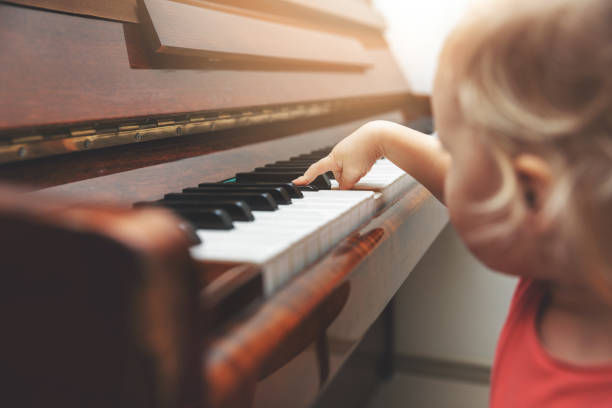 istock music education - child pushing piano keys 1066517886