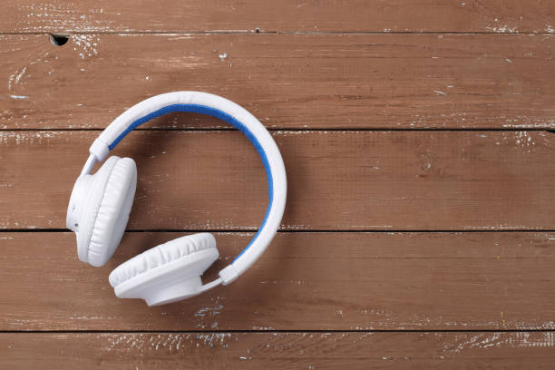 istock Musical equipment - White wireless headphone wood background 1066518754