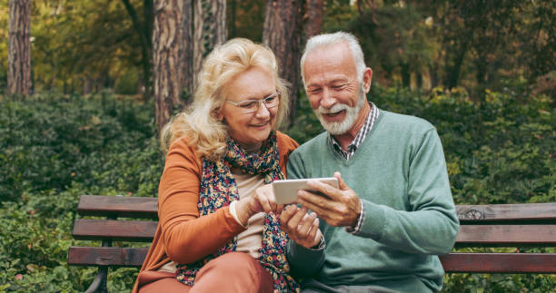 istock Senior couple using smart phone in the park 1066523338