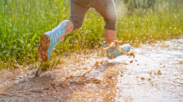 istock Girl playing in muddy water 1066529862