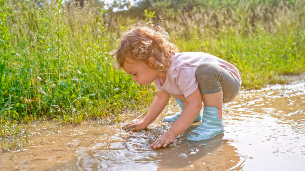 istock Girl playing in muddy water 1066529872