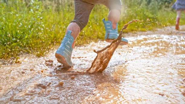 istock Girl playing in muddy water 1066529886