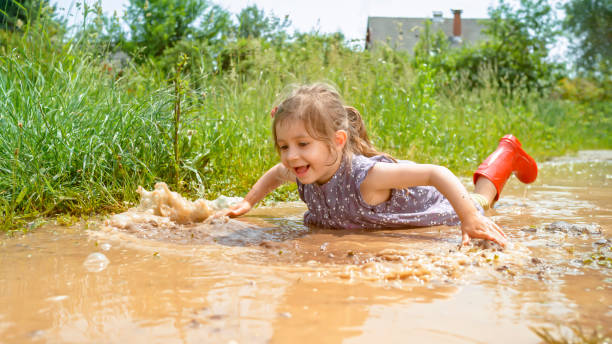 istock Girl playing in muddy water 1066529916