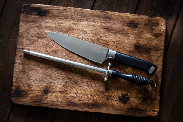 istock Sharpening steel and kitchen knife on wooden cutting board 1066533414