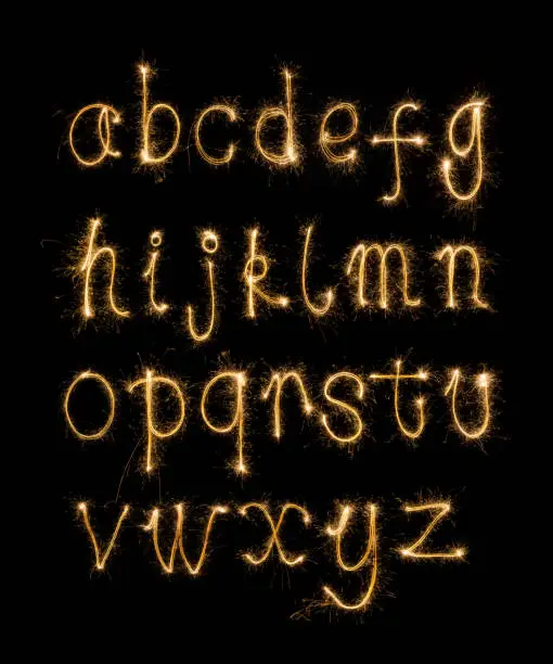 Photo of Alphabet sparklers on black background