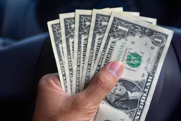 istock Hand holding dollar money in car 1066545232