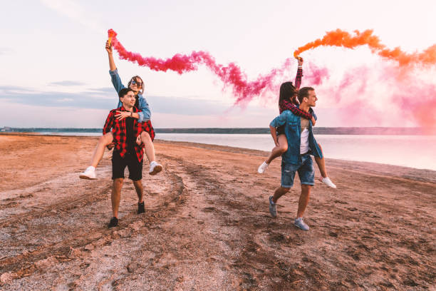 istock young friends running with hand flare or fusee 1066554662
