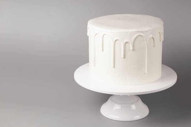Simple white cake with glaze on a gray background. Simple white cake with glaze on a gray background. cake models stock pictures, royalty-free photos & images