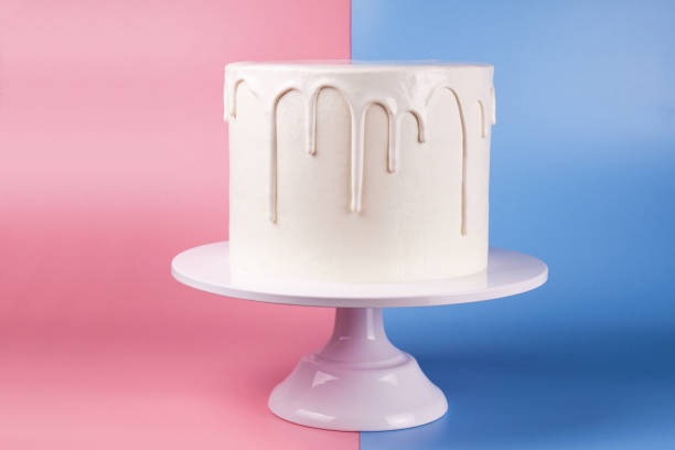 istock Simple white cake with white glaze on a pink and blue background. 1066555486