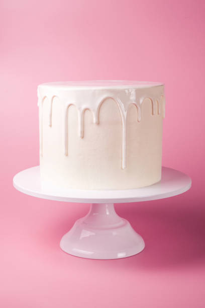 istock Simple white cake with white glaze on a pink background. 1066555510