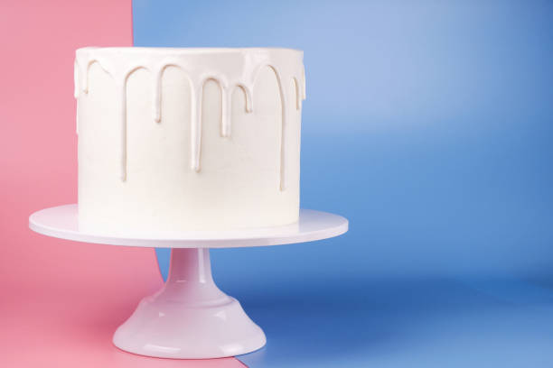 istock Simple white cake with white glaze on a pink and blue background. 1066555560