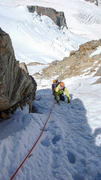 client masculin leader au sommet d’une crête alpine haute sur une belle journée de montagne guide - piz palü photos et images de collection