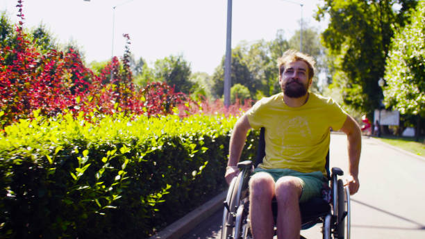 istock Young disable man in wheelchair in the park 1066566156