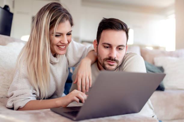 istock Young couple relaxing on sofa with laptop 1066575896