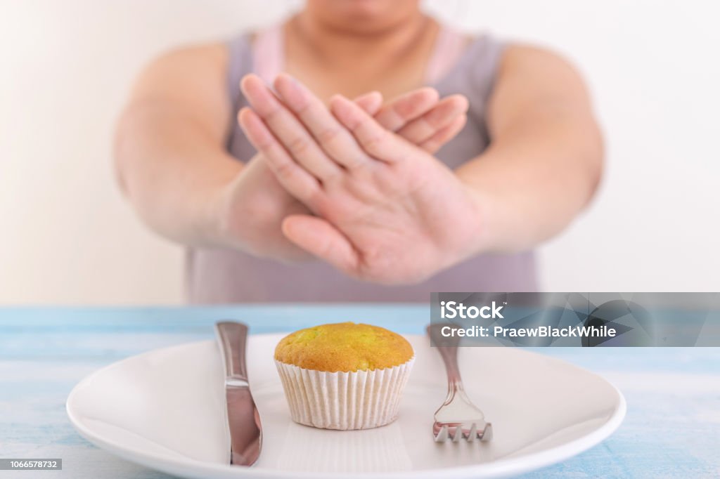 fat woman rejecting cupcake or unhealthy food. Health care concept. Fasting - Activity Stock Photo