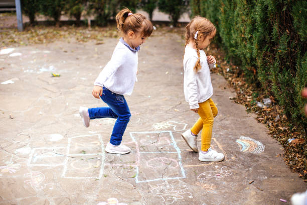 Girls Playing Hopscotch Girls Playing Hopscotch rail fence stock pictures, royalty-free photos & images