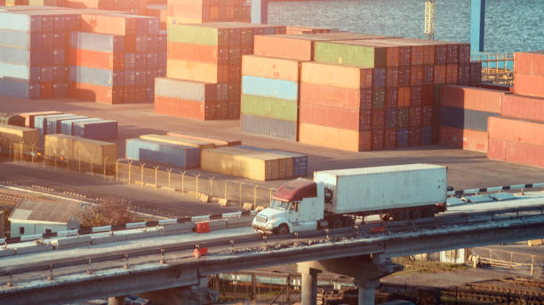 cina shippnig, camion nel porto con tanti container - blue bulk business cargo container foto e immagini stock
