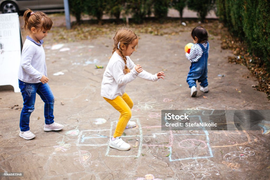 Kids playing hopscotch on playground outdoors - Royalty-free Jogo da Semana Foto de stock