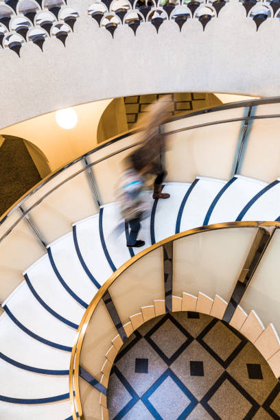 istock Motion Blur of People on Abstract Spiral Staircase 1066585358
