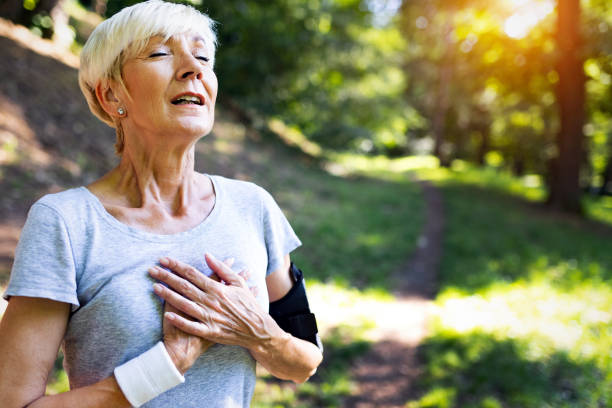 l'atleta donna matura ha dolore al petto sinistro vertigini - senior male immagine foto e immagini stock