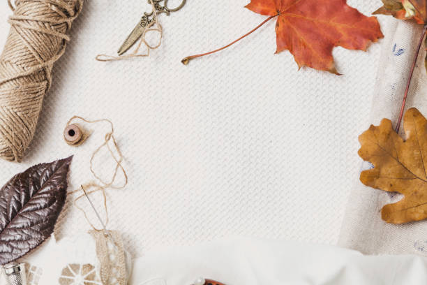 istock Scissors, thread and fallen leaves lie on white cloth 1066596788