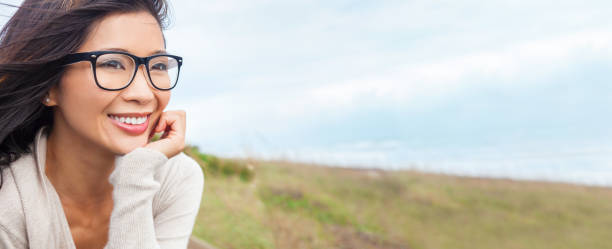 Web banner panoramic portrait of a beautiful chinese asian girl or young woman outside wearing glasses - fotografia de stock