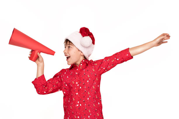 istock Boy in Santa hat holding red megaphone 1066604016