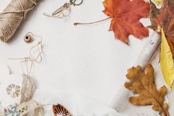 istock Scissors, thread and fallen leaves lie on white cloth 1066606136