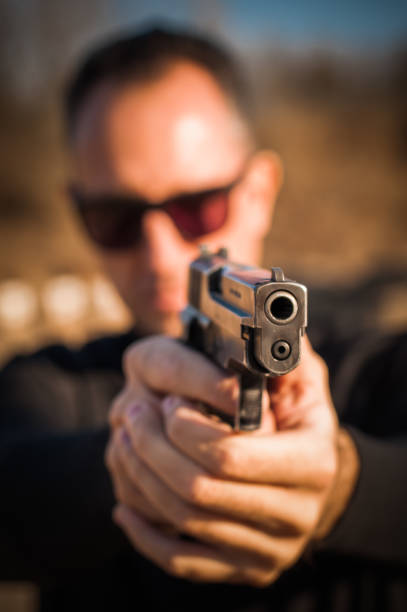 istock Police agent bodyguard gun pointing pistol to attacker. Front view 1066608894