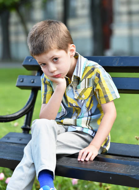 istock sad child boy sitting on a bench 1066614994