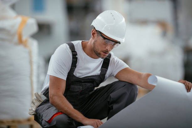 istock Factory worker with blueprint controlling production 1066615306