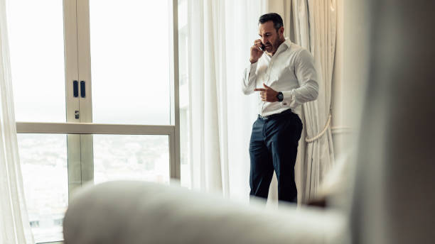 istock Businessman making a phone call from hotel room 1066615780