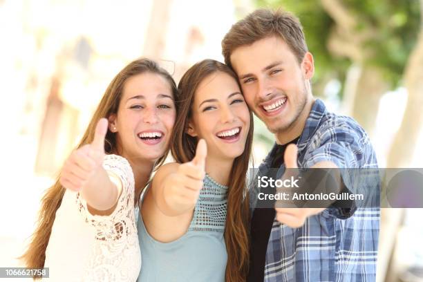 Three Happy Friends Smiling With Thumbs Up In The Street Stock Photo - Download Image Now