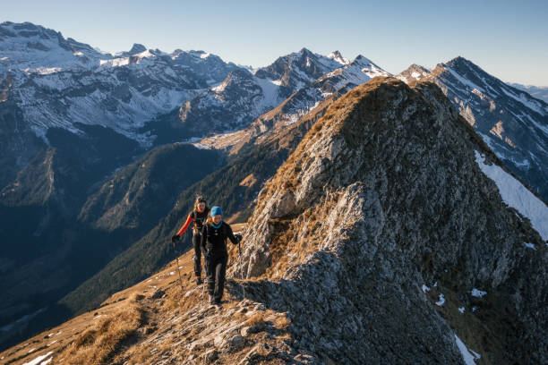 Female mountaineers moving up mountain ridge