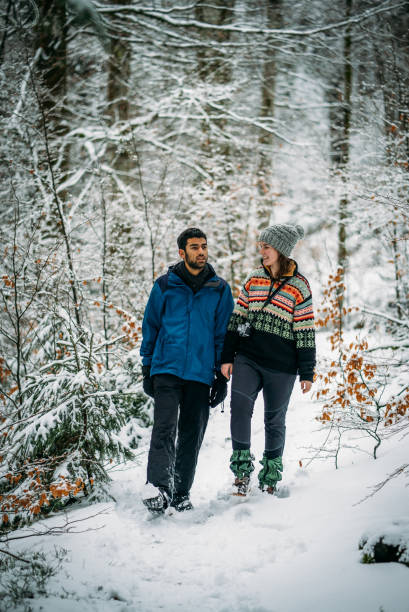 istock Couple walks through wintery forest 1066622108