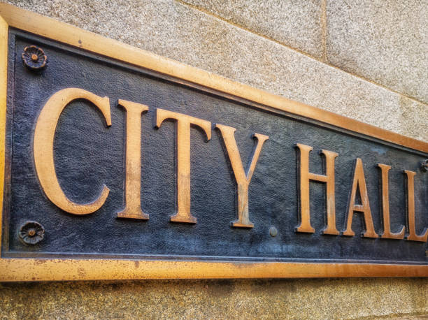 Exterior sign that reads "City Hall" in brass letters. Close up. stock photo