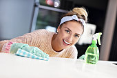 Happy woman cleaning kitchen countertop